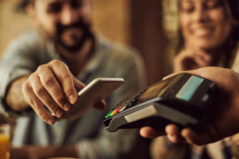 closeup-man-making-contactless-payment-with-smart-phone-768x512